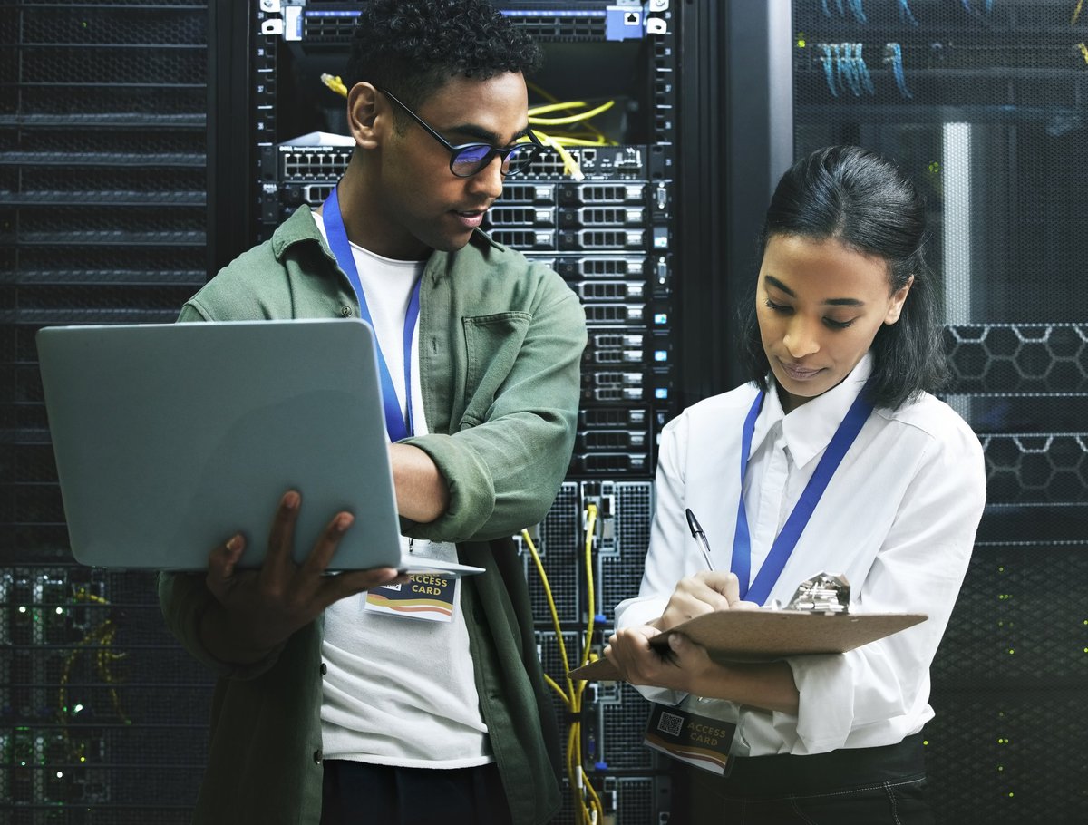 Two IT professionals collaborating on-site, working on network hardware together